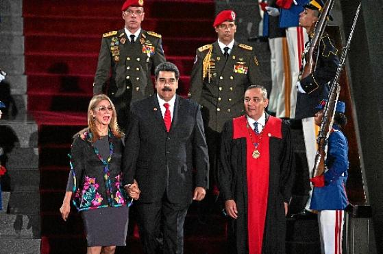 Acompanhado da primeira-dama, Cilia Flores, e do presidente do TSJ, Maikel Moreno (D), Maduro chega à solenidade de juramento, em Caracas (Yuri Cortez/AFP)