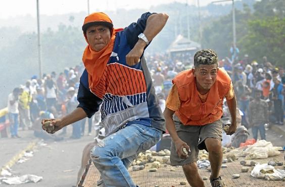 Venezuelanos lançam pedras contra as forças de segurança na ponte internacional entre Cúcuta (Colômbia) e Ureña (Raul  Arboleda/AFP)