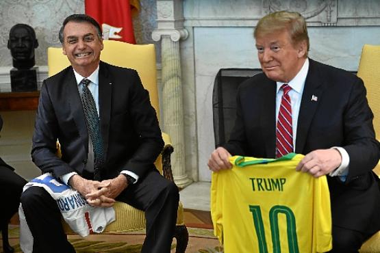 Bolsonaro e Trump trocam camisas das seleções: bom humor, coincidências e o acerto para o Brasil apoiar decisões dos EUA na questão da Venezuela (Brendan Smialowski/AFP)