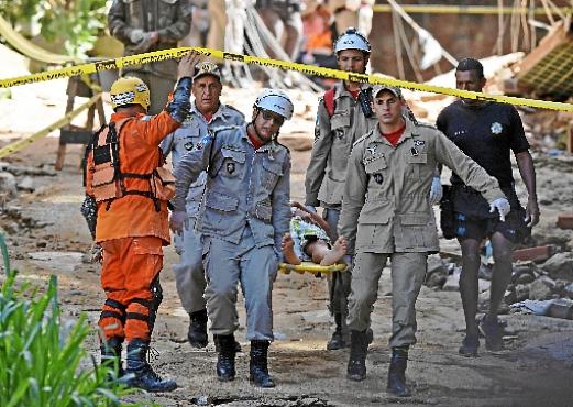 Bombeiros carregam um dos feridos resgatados dos escombros (Carl de Souza/AFP)