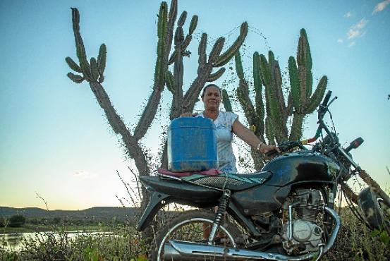 Marilene usa a moto para pegar água em um açude duas vezes por dia: o dinheiro é obtido com a Bolsa Família e a pequena roça (Andre Pessoa/Esp. CB/D.A Press)