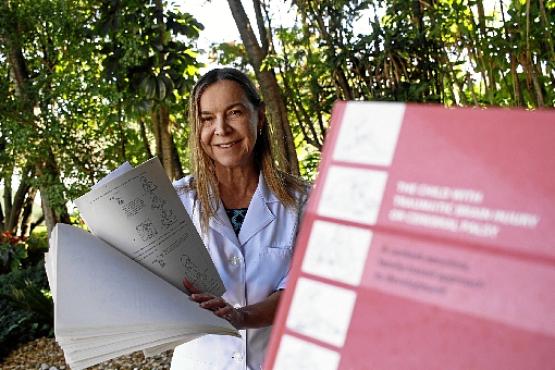 Lúcia mostra trabalho datilografado na década de 1980 que deu origem a livro sobre reabilitação de crianças com paralisia cerebral (Ana Rayssa/CB/D.A Press)