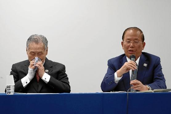 O presidente Yoshiro Mori (E) e o diretor executivo do Comitê Organizador dos Jogos de Tóquio-2020, Yoshiro Mori, lamentam a transferência do megaevento para o ano que vem (Behrouz Mehri/AFP)