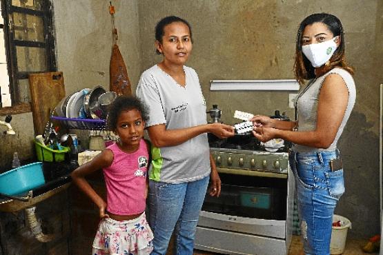 Francisca Oliveira e a filha Ana Luísa recebem cupom de alimentação da auxiliar do projeto Francely Rocha  (Marcelo Ferreira/CB/D.A Press)