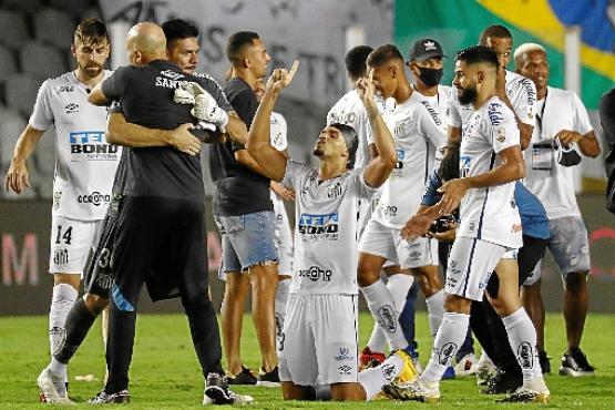 O zagueiro Lucas Veríssimo (C), com uma proteção na cabeça após sangrar em campo, foi um símbolo da disposição do time da Vila contra o rival argentino (Sebastiao Moreira/AFP)