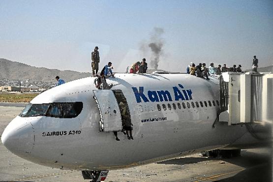 Afegãos escalam aeronave da companhia local Kam Air, no Aeroporto Internacional Hamid Karzai: pânico ao tentar abandonar país  (Wakil Kohsar/AFP)