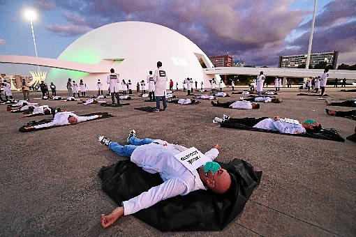 No Dia Internacional da Enfermagem, ontem, profissionais da saúde homenagearam homens e mulheres que morreram na linha de frente do combate à covid-19. Os números da doença avançam no Brasil: são 12,4 mil mortos %u2013 881 em 24 horas %u2013 177,5 mil infectados. No DF, há 3 mil casos e 46 mortes. (Evaristo Sá / AFP)