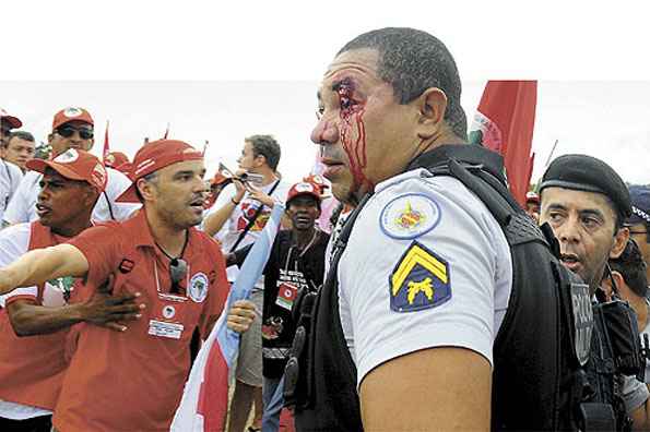 Enquanto o Congresso discutia o projeto de lei que enquadra protesto contra a Copa como ato terrorista, sem-terra alinhados com o Planalto quase linchavam PMs. Medo de invasão fez o STF suspender trabalhoO PT foi orientado pelo governo a propor mudanças na lei antiterror para evitar que movimentos sociais, como o MST %u2014 que ontem entrou em confronto com militares %u2014, possam ser enquadrados pela polêmica legislação. Mas brasileiros sem vínculos com esse tipo de organização correrão o risco de serem condenados como terroristas se saírem às ruas para protestar. Na Praça dos Três Poderes, ontem, só não ocorreu uma tragédia porque um grupo de ativistas fez uma barreira humana e impediu que manifestantes partissem para cima de policiais encurralados no meio da multidão (estimada em 15 mil pessoas). Segundo a PM, 30 policiais e pelo menos três manifestantes ficaram feridos. Hoje, os sem-terra terão um encontro com a presidente Dilma. (Janine Moraes/CB/D.A Press) Enquanto o Congresso discutia o projeto de lei que enquadra protesto contra a Copa como ato terrorista, sem-terra alinhados com o Planalto quase linchavam PMs. Medo de invasão fez o STF suspender trabalhoO PT foi orientado pelo governo a propor mudanças na lei antiterror para evitar que movimentos sociais, como o MST %u2014 que ontem entrou em confronto com militares %u2014, possam ser enquadrados pela polêmica legislação. Mas brasileiros sem vínculos com esse tipo de organização correrão o risco de serem condenados como terroristas se saírem às ruas para protestar. Na Praça dos Três Poderes, ontem, só não ocorreu uma tragédia porque um grupo de ativistas fez uma barreira humana e impediu que manifestantes partissem para cima de policiais encurralados no meio da multidão (estimada em 15 mil pessoas). Segundo a PM, 30 policiais e pelo menos três manifestantes ficaram feridos. Hoje, os sem-terra terão um encontro com a presidente Dilma. (Janine Moraes/CB/D.A Press)