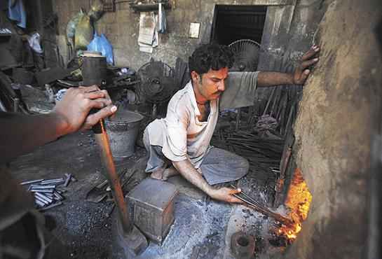 Paquistanês perto de forno a carvão: a poluição em casa mata mais que a externa (Akhtar  Soomro/Reuters - 28/3/11)