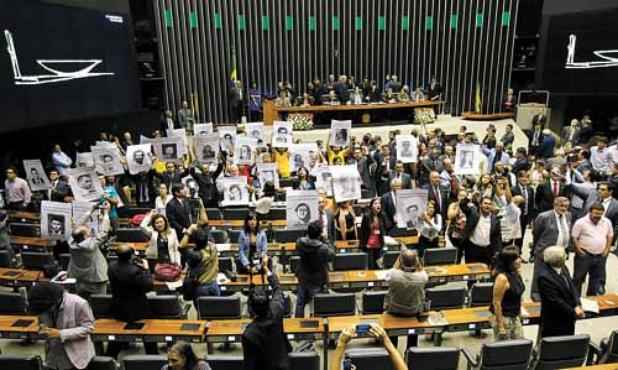 Integrantes de movimentos sociais ficam de costas para a tribuna da Câmara: solenidade interrompida (Sérgio Lima/Folhapress)