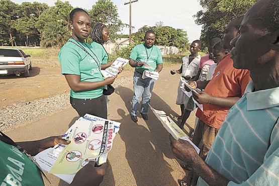 Voluntários distribuem panfletos com orientações a moradores de Monróvia, capital da Libéria: vírus já matou 255 pessoas no país desde março (Samaritan's Purse/Reuters)
